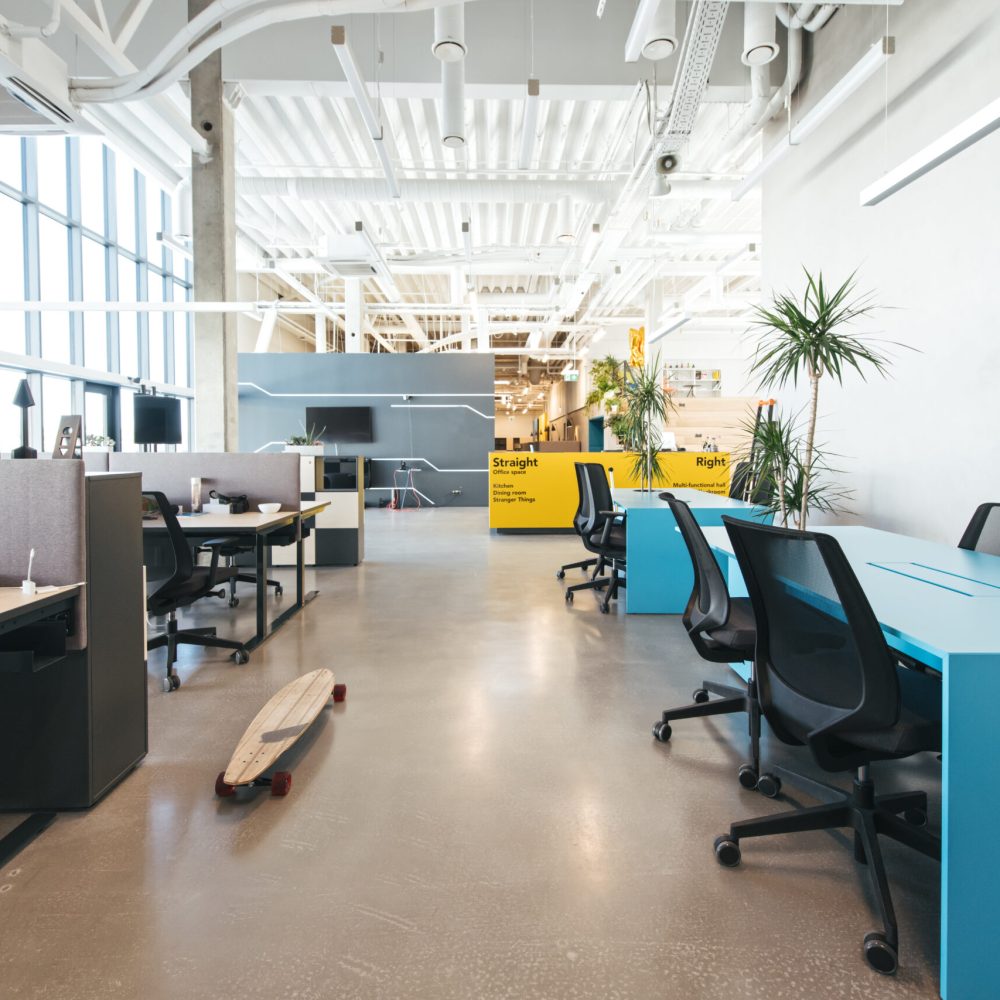 Inside shot of new stylish open space office with contemporary design and high ceiling in daylight